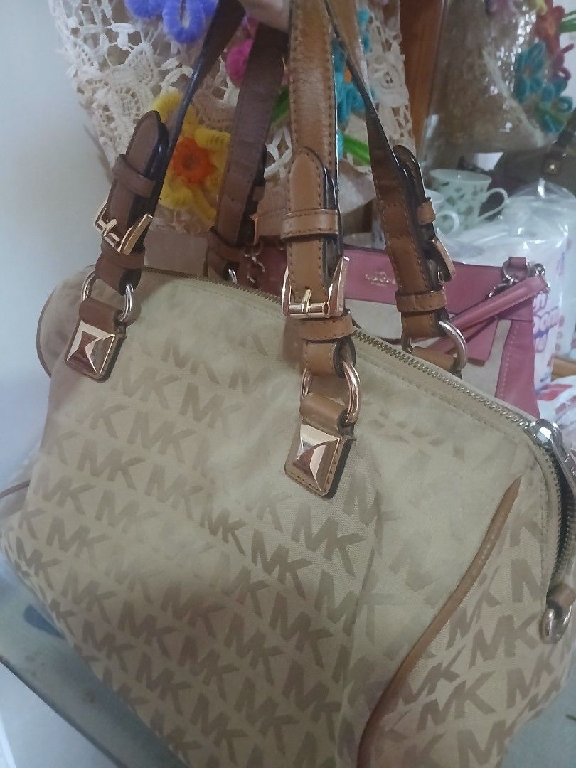 Michael Kors Monogram Canvas Tote Bag (Category: Luxury Bags & Wallets) located in Abucay. Submitted by mimasshop (Listing ID 1461564310, Image 3). Description: -NOTE: HAS MINOR ISSUES AT THE HANDLE AND ZIPPER (DISCOUNTED) - Classic Michael Kors tote bag - Beige canvas with signature MK monogram pattern - Tan leather trim and straps - Gold-tone hardware - Zipper closure - Spacious interior for essentials - Ideal everyday bag.