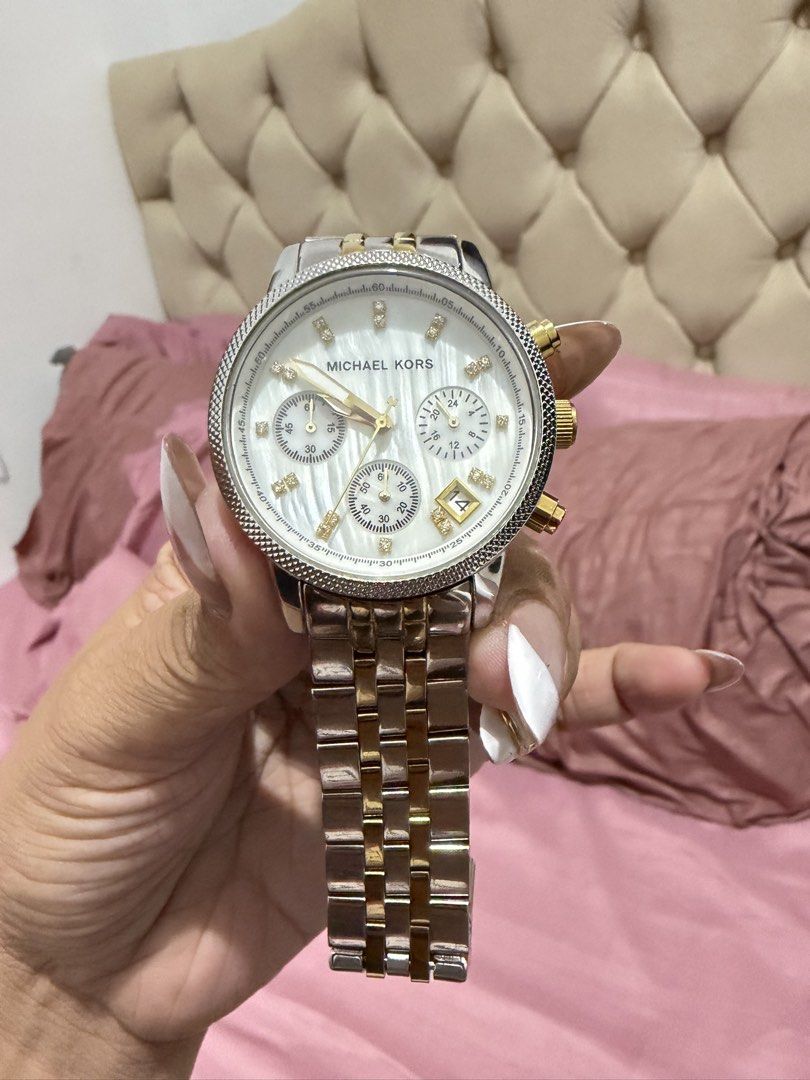 Michael Kors Two-Tone Chronograph Watch (Category: Women's Watches) located in Muntinlupa City. Submitted by trendeemoodshop2022 (Listing ID 1461726289, Image 2). Description: ✅Michael Kors watch. ✅Two-tone stainless steel band with gold accents. ✅White dial with diamond hour markers. ✅Chronograph function. Looks great on the wrist. ✅Selling because I don't wear it often anymore. Let me know if you have questions. ✅Selling Watch only napatapon na