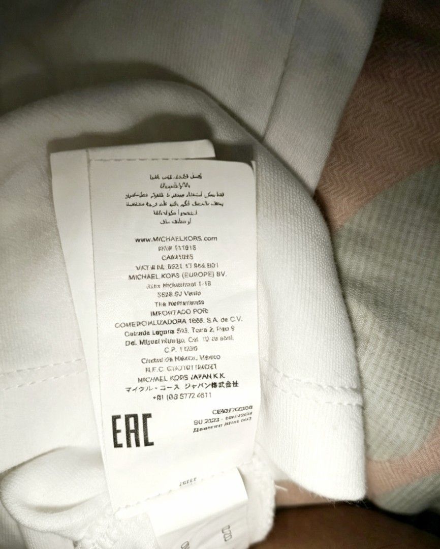 Michael Kors White V-Neck T-Shirt (Category: Tshirts & Polo Shirts ) located in Manila. Submitted by noblehorse-dccec0 (Listing ID 1461734973, Image 3). Description: - Classic white V-neck t-shirt - Authentic Michael Kors - Features a subtle MK logo on the chest - Made from soft, comfortable cotton fabric - Versatile basic for everyday wear - Medium on tag but fit to Large dimes; 21x27.