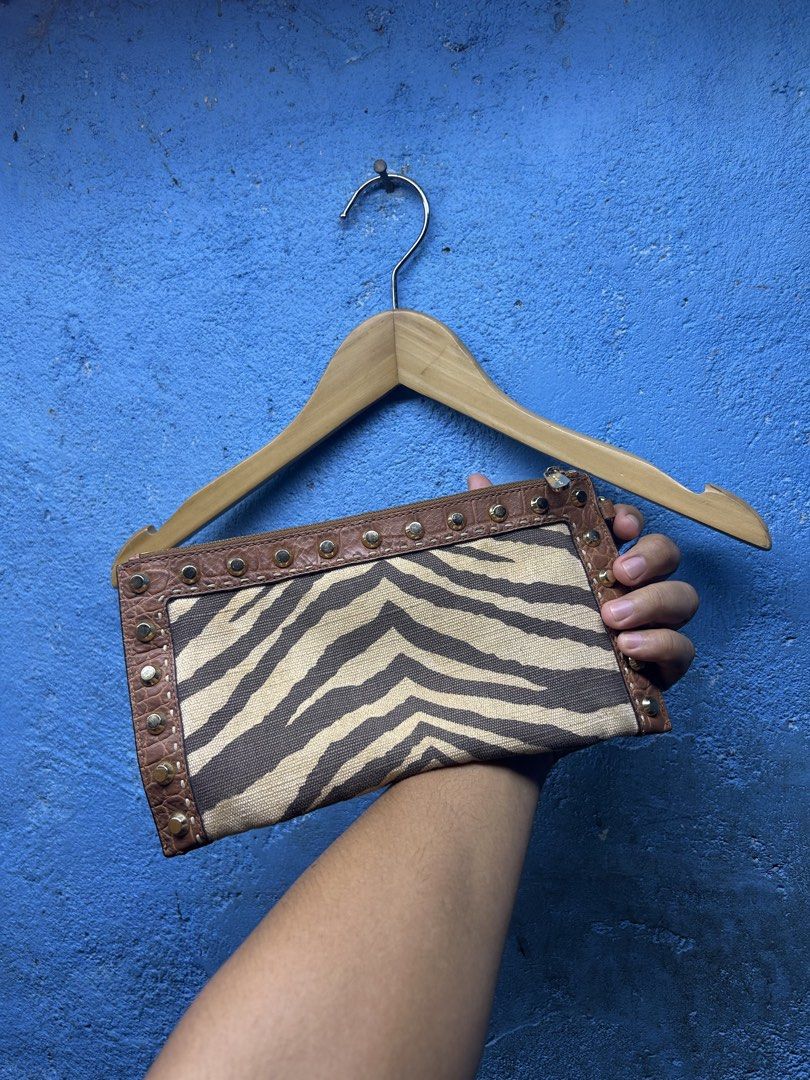 Michael Kors Zebra Print Clutch with Studs (Category: Clutches) located in Quezon City. Submitted by thriftxgoods (Listing ID 1461658287, Image 2). Description: - Stylish Michael Kors clutch - Eye-catching zebra print - Genuine brown leather trim - Elegant gold stud detailing - Secure zipper closure - Convenient interior pocket - Detachable wrist strap for easy carrying - Ideal for holding your essentials.