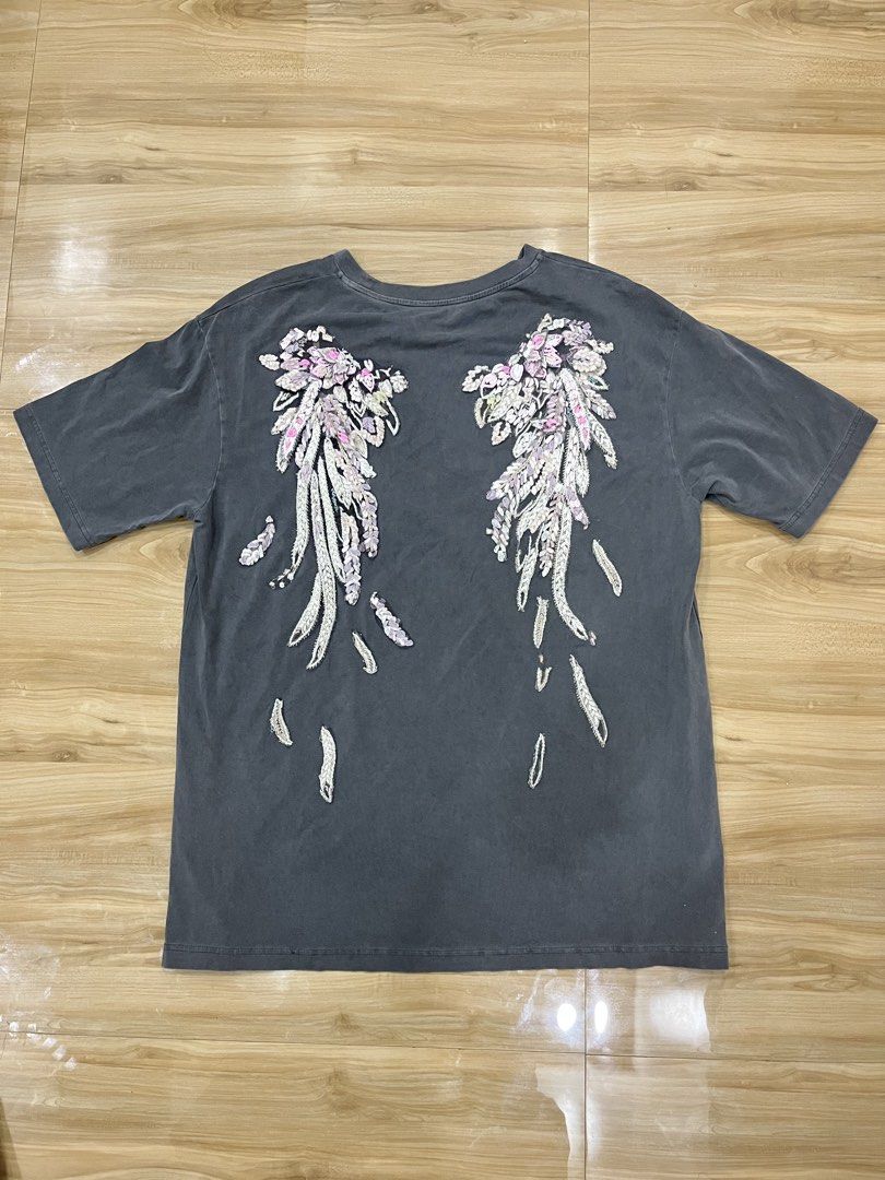 Miss Sixty T-Shirt (Category: Shirts) located in Angeles City. Submitted by thriftsij (Listing ID 1461765534, Image 2). Description: - Grey Miss Sixty t-shirt with back design - Features the iconic Miss Sixty logo on the front - Unique floral-like embellishments with pink and white details on the back - Minor distressed holes near the neckline add character - Size: EUR XS - Perfect statement piece to elevate your style.
