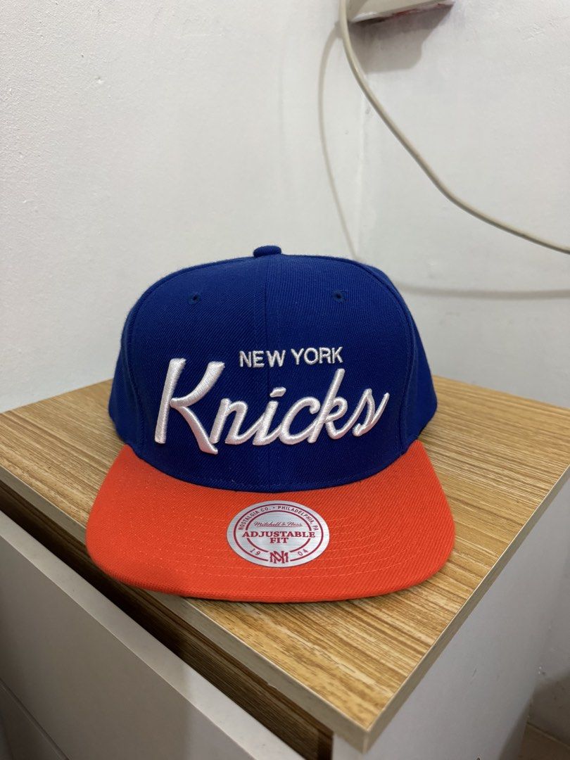 Mitchell & Ness New York Knicks Snapback Cap (Category: Caps & Hats) located in Bulacan. Submitted by alshopie (Listing ID 1461635956, Image 1). Description: - Mitchell & Ness New York Knicks snapback cap - Royal blue crown with orange brim - Adjustable strap at the back - Classic fit - Perfect for Knicks fans.