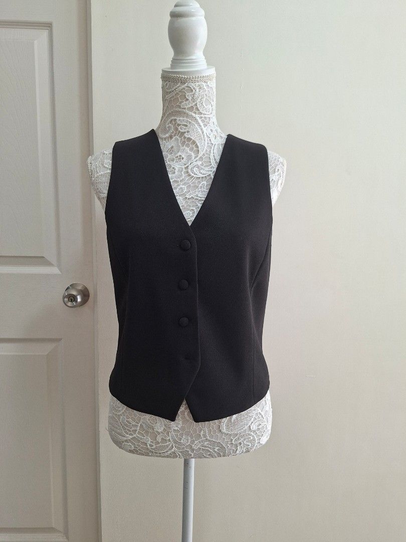 MNG Black Sleeveless Vest Size M (Category: Sleeveless) located in Pasig City. Submitted by avcan (Listing ID 1461576796, Image 1). Description: - MNG black sleeveless vest - Button-up front with 3 buttons - Made in Vietnam - Ideal for layering over shirts or dresses - Versatile for smart casual or formal looks - Please check photos for condition details - Note that one button at the bottom is not attached, but I pinned it to the washtag (DIY sew