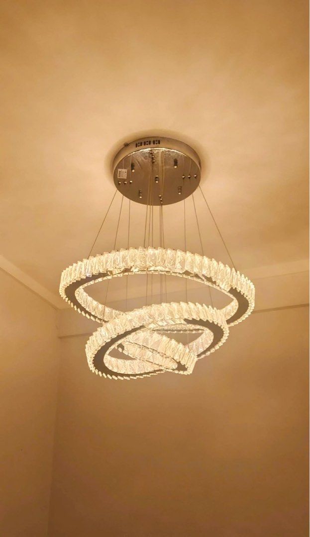 Modern Crystal Ring Chandelier Light Fixture (Category: Lighting) located in Manila. Submitted by d_carthub (Listing ID 1461590410, Image 3). Description: - Beautiful modern chandelier - Features three intertwined crystal rings - Silver-toned metal base - Emits bright, clear light, warm light - Ideal for living rooms, dining areas, or entryways - Adds a touch of sparkle - Wiring and mounting hardware included - 3 way light color.