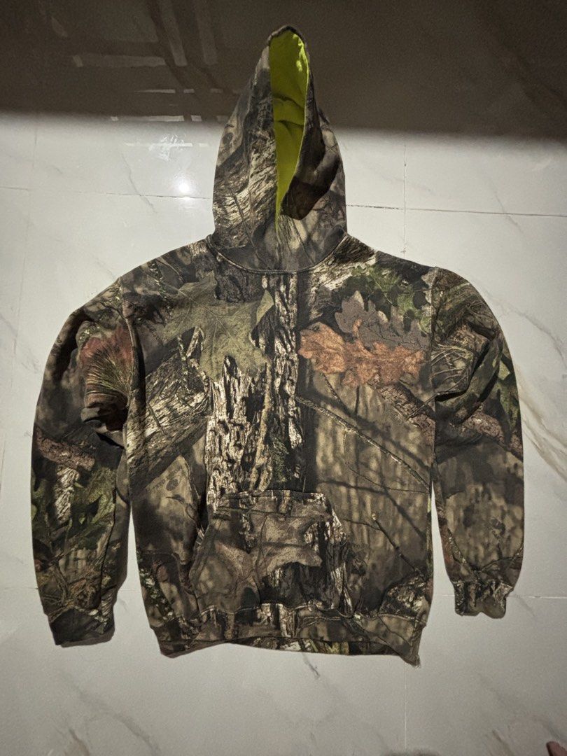 Real tree Mossy Oak Camo Hoodie (Category: Hoodies) located in Bulacan. Submitted by vtglover_ (Listing ID 1461707883, Image 1). Description: - Mossy Oak camouflage pattern - Bright neon yellow interior lining - Front kangaroo pocket - Ribbed cuffs and hem - Ideal for outdoor activities and casual wear.