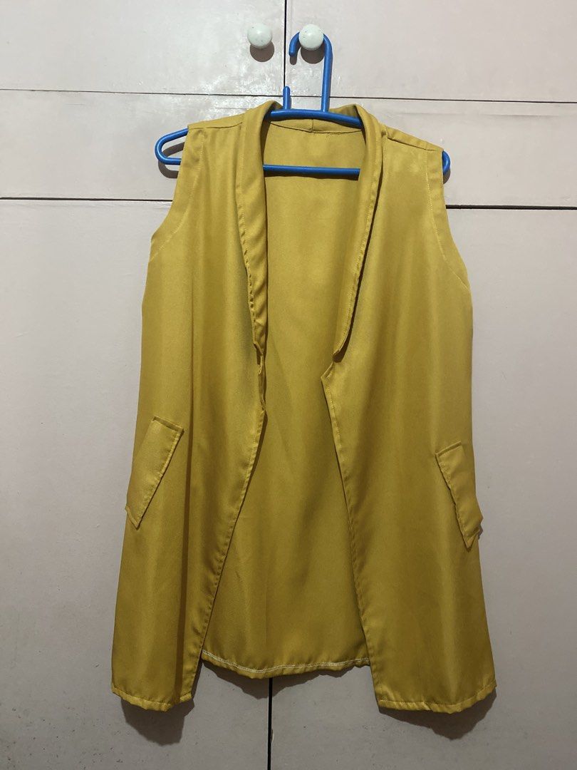 Mustard Yellow Sleeveless Vest (Category: Sleeveless) located in Manila. Submitted by angelaay143 (Listing ID 1461780731, Image 2). Description: - Mustard sleeveless vest - Open front with lapels - Two pocket design (not functional) - Material has a slight sheen - Versatile layering piece for dresses or tops - Used once - Needs laundry atored too long at the cabinet.