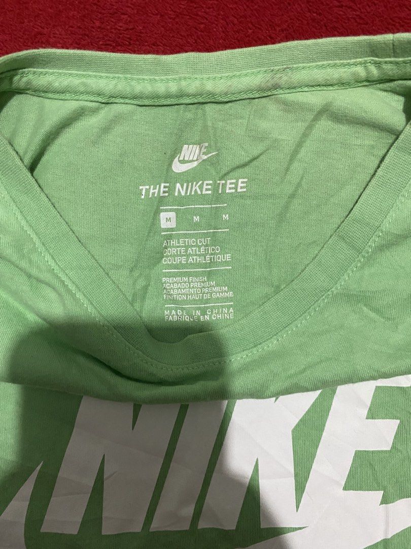 Nike Tee Green Men's Athletic Cut Size M (Category: Activewear) located in Makati City. Submitted by dymon_08 (Listing ID 1461766709, Image 2). Description: - Green Nike athletic tee - Size: Medium - Material: 100% Cotton - Origin: Made in China - Condition: Good, with a slight mark on the left shoulder (circled in photo).