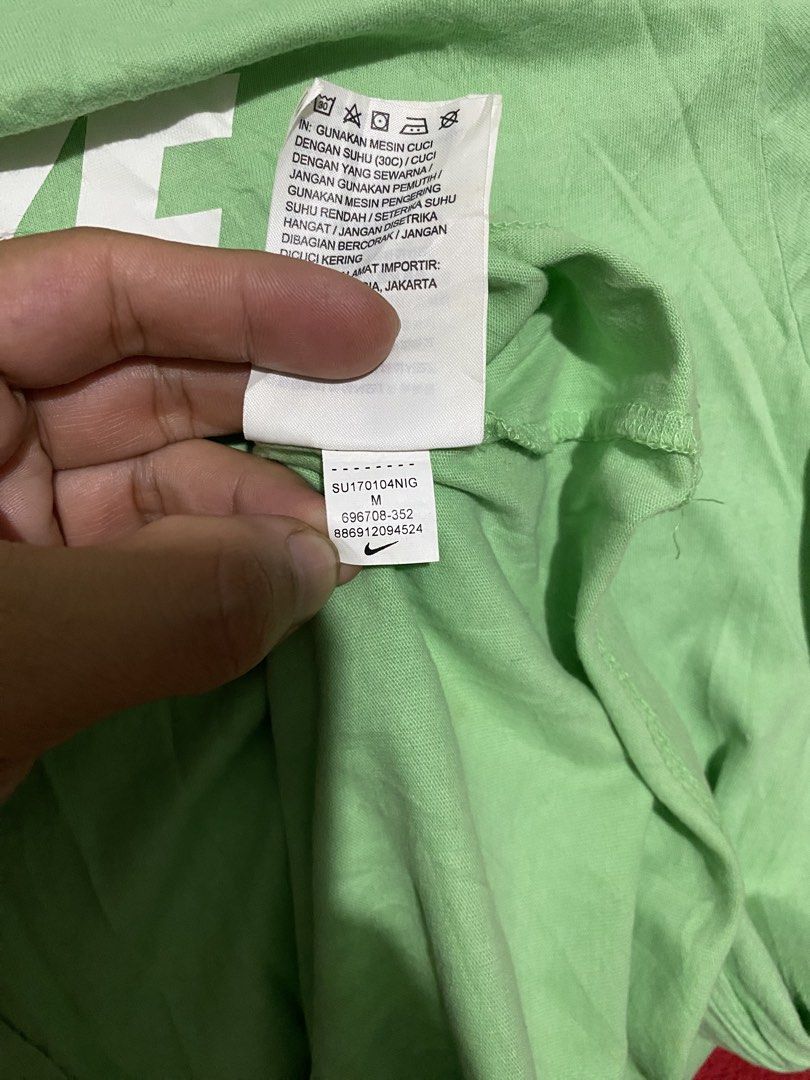 Nike Tee Green Men's Athletic Cut Size M (Category: Activewear) located in Makati City. Submitted by dymon_08 (Listing ID 1461766709, Image 3). Description: - Green Nike athletic tee - Size: Medium - Material: 100% Cotton - Origin: Made in China - Condition: Good, with a slight mark on the left shoulder (circled in photo).