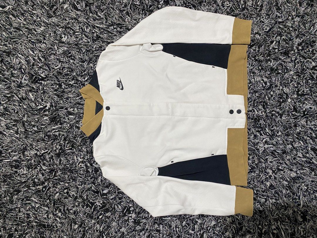 Nike White Black Tan Colorblock Bomber Jacket (Category: Coats, Jackets and Outerwear) located in Baguio. Submitted by arenzu (Listing ID 1461750356, Image 1). Description: - Cool Nike bomber jacket - White body with black and tan colorblock - Snap button closure - Estimated size Medium (please check measurements) - Perfect for casual wear.