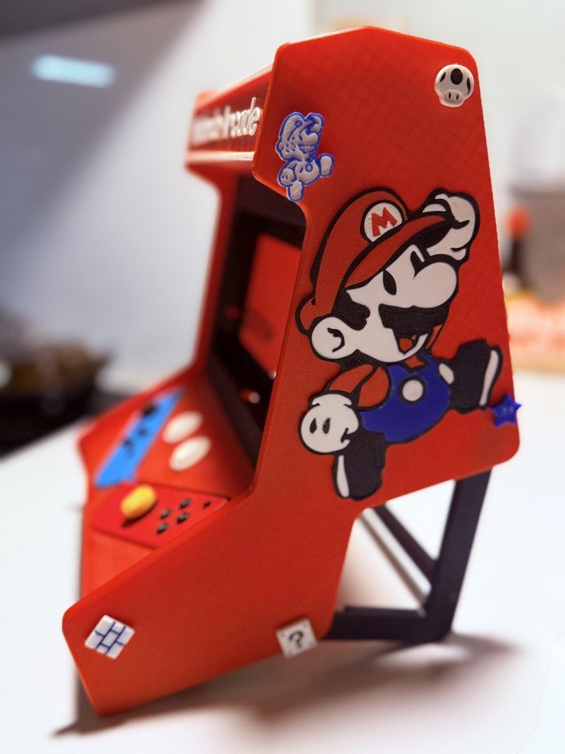 Nintendo Arcade Mini Machine with Mario Party Superstars (Category: Nintendo) located in Manila. Submitted by irish_c (Listing ID 1461685516, Image 3). Description: - Mini Nintendo Arcade Machine - Features Mario Party Superstars on screen - Comes with blue and red Joy-Con style controllers - Includes a pull-out tray at the bottom - Decorated with Mario and other Nintendo characters - Approximately 29cm tall.