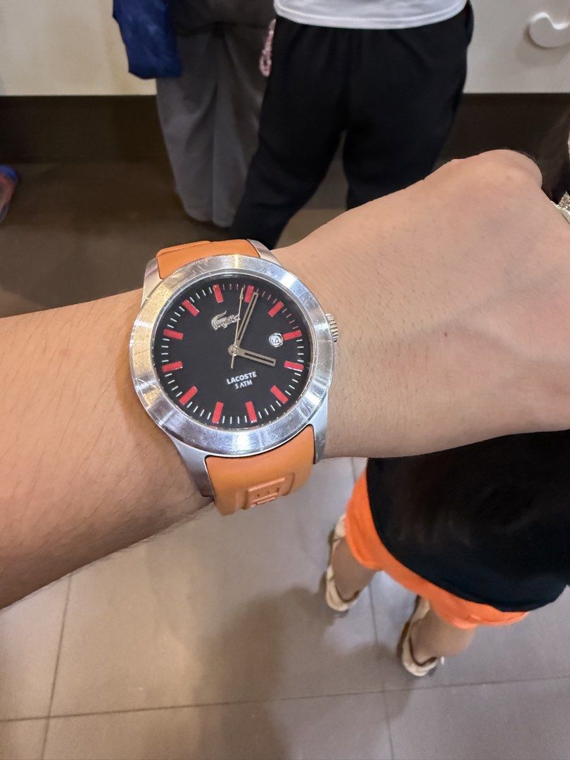 Original Lacoste Watch (Category: Women's Watches) located in Muntinlupa City. Submitted by trendeemoodshop2022 (Listing ID 1461645155, Image 2). Description: - Authentic Lacoste watch - Vibrant orange strap - Sleek black dial with striking red accents - Convenient date window at 3 o'clock - Durable stainless steel case - Water resistant up to 50 meters (5 ATM) - Ideal for everyday wear and casual styling - Selling as it's no longer part of my ro