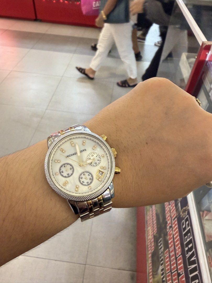 Original MK Watch (Category: Women's Watches) located in Muntinlupa City. Submitted by trendeemoodshop2022 (Listing ID 1461643630, Image 2). Description: ✅Michael Kors watch. ✅Two-tone stainless steel band with gold accents. ✅White dial with diamond hour markers. ✅Chronograph function. Looks great on the wrist. ✅Selling because I don't wear it often anymore. Let me know if you have questions. ✅Selling Watch only napatapon na ang box and other inc