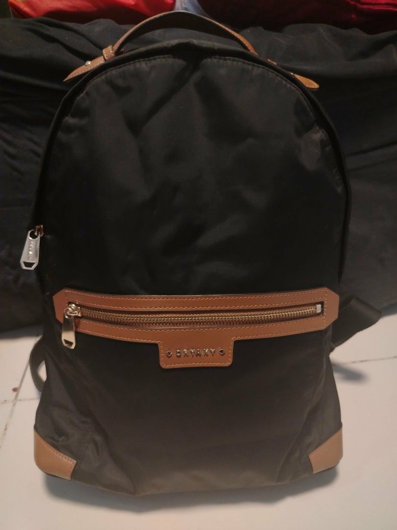 ORYANY Black Nylon Backpack with Tan Leather Accents (Category: Backpacks) located in Manila. Submitted by wildwind_73f77a (Listing ID 1461584402, Image 1). Description: - ORYANY black nylon backpack - Tan leather trim on front zip pocket and base - Interior lining with geometric pattern - Adjustable shoulder straps - Ideal for everyday use or travel.