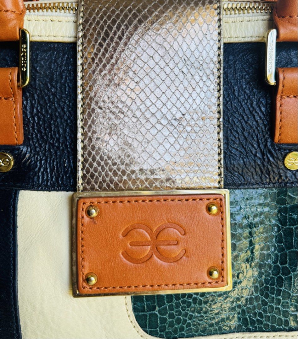 Patchwork Handbag (Category: Luxury Bags & Wallets) located in Bacolod City. Submitted by vintage_vogue6100 (Listing ID 1461667628, Image 2). Description: Style & Shape: A structured, barrel-shaped satchel bag (similar to a Boston bag) with dual rolled top handles and a main zipper closure. Colors & Patterns: A multi-colored blocked design combining navy blue, cream, orange, and emerald green paneling. Textures: A mix of pebbled leather, smooth c