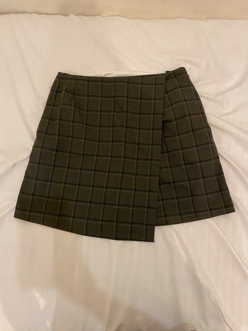 Plaid Mini Skirt (Category: Skirts) located in Quezon City. Submitted by pixavix (Listing ID 1461706882, Image 2). Description: - Olive green plaid mini skirt - Wrap style with a slight asymmetry - Estimated size: Small to Medium - Perfect for casual outings or dressing up - Easy to pair with various tops and shoes.
