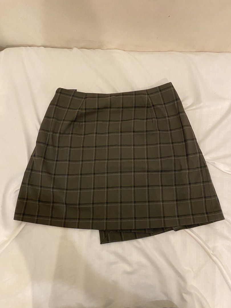 Plaid Mini Skirt (Category: Skirts) located in Quezon City. Submitted by pixavix (Listing ID 1461706882, Image 1). Description: - Olive green plaid mini skirt - Wrap style with a slight asymmetry - Estimated size: Small to Medium - Perfect for casual outings or dressing up - Easy to pair with various tops and shoes.