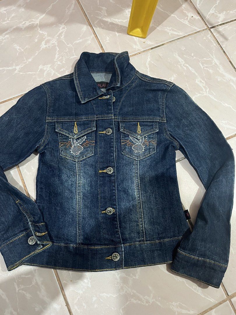 Playboy Denim Jacket with Bunny Embroidery (Category: Coats, Jackets and Outerwear) located in Tabuk. Submitted by collectors_thrift_shop (Listing ID 1461636852, Image 1). Description: - Playboy Dark Wash Denim Jacket - Features embroidered bunny details on chest pockets - Button-up front with classic collar - Material: 98% Cotton, 2% Elastic - Ideal for casual wear - Please check photos for size tag.