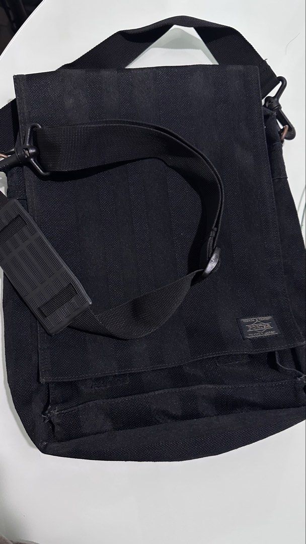 Porter Yoshida & Co. Black Striped Messenger Bag (Category: Sling Bags) located in Mandaluyong City. Submitted by TheWeekendProject (Listing ID 1461713781, Image 3). Description: - Brand: Porter Yoshida & Co. - Color: Black - Design: Subtle vertical stripe pattern - Compartments: Main compartment with internal pockets, zippered front pocket - Strap: Adjustable shoulder strap with padding (note: this is a replacement strap) - Use: Ideal for everyd