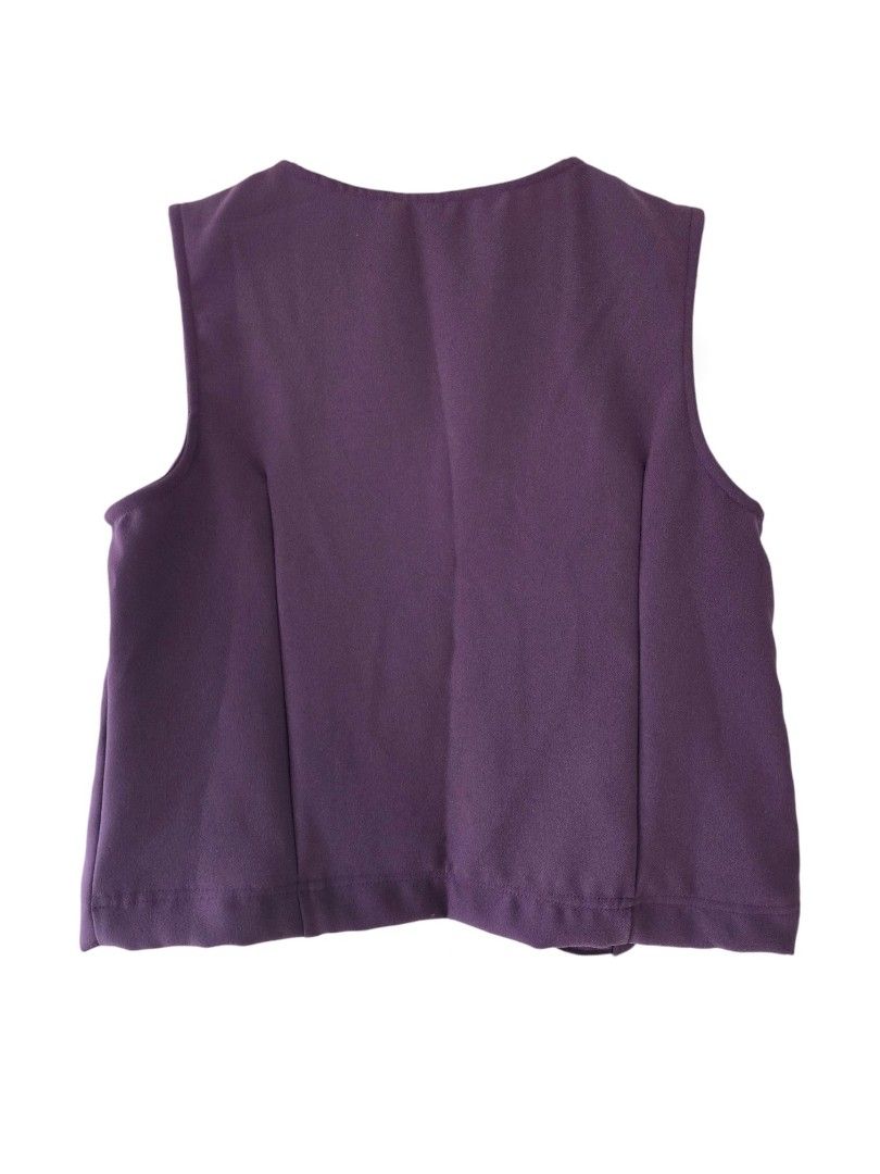 Purple Button-Up Sleeveless Vest (Category: Sleeveless) located in Cainta. Submitted by piper8 (Listing ID 1461580200, Image 2). Description: -Dimensions laid flat: Legth: 56 cm chest: 46 cm sleeve hole: 22 cm - Deep purple sleeveless vest - Round neckline - Button-up front with 4 matching buttons - Unique curved hemline - Subtle textured fabric finish - Ideal for layering over any outfit.