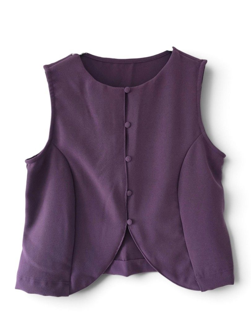 Purple Button-Up Sleeveless Vest (Category: Sleeveless) located in Cainta. Submitted by piper8 (Listing ID 1461580200, Image 1). Description: -Dimensions laid flat: Legth: 56 cm chest: 46 cm sleeve hole: 22 cm - Deep purple sleeveless vest - Round neckline - Button-up front with 4 matching buttons - Unique curved hemline - Subtle textured fabric finish - Ideal for layering over any outfit.