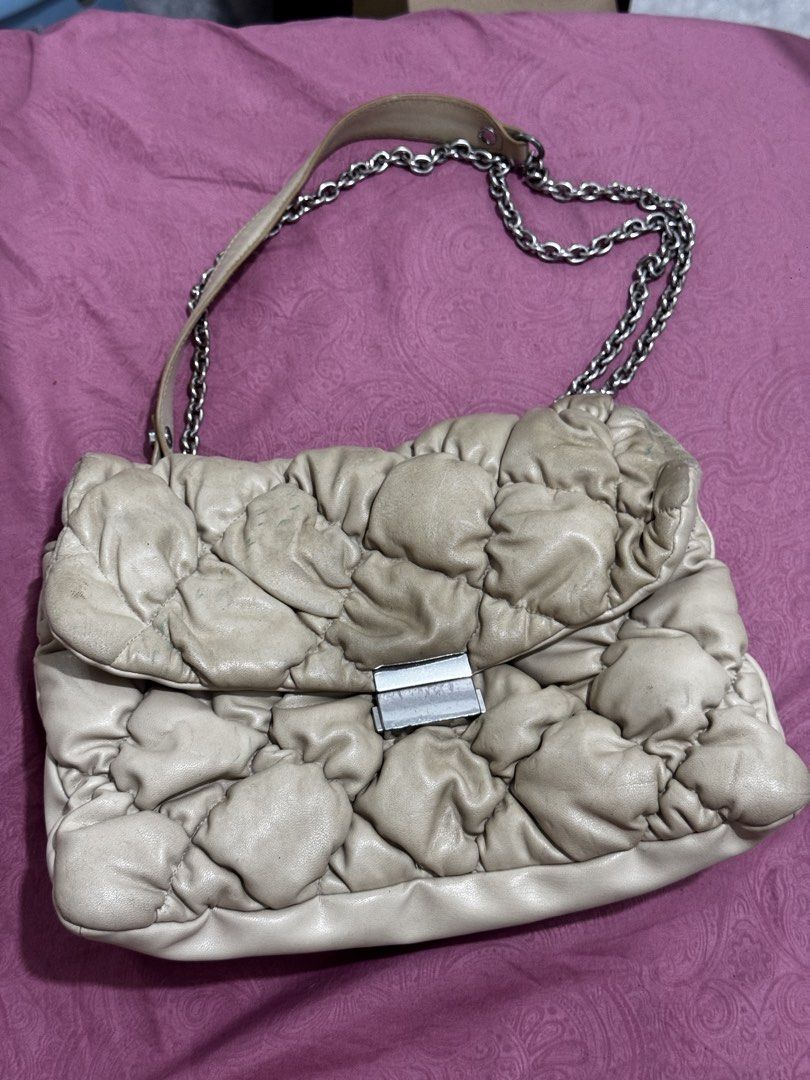 Quilted Leather Chain Shoulder Bag (Category: Shoulder Bags) located in Bauang. Submitted by jeneefromtheblock (Listing ID 1461774703, Image 1). Description: - Cream-colored quilted leather shoulder bag - Silver hardware with clasp closure - Chain strap with comfortable leather shoulder pad - Multiple interior compartments for organization - Marks on exterior leather - Clasp shows some signs of wear.