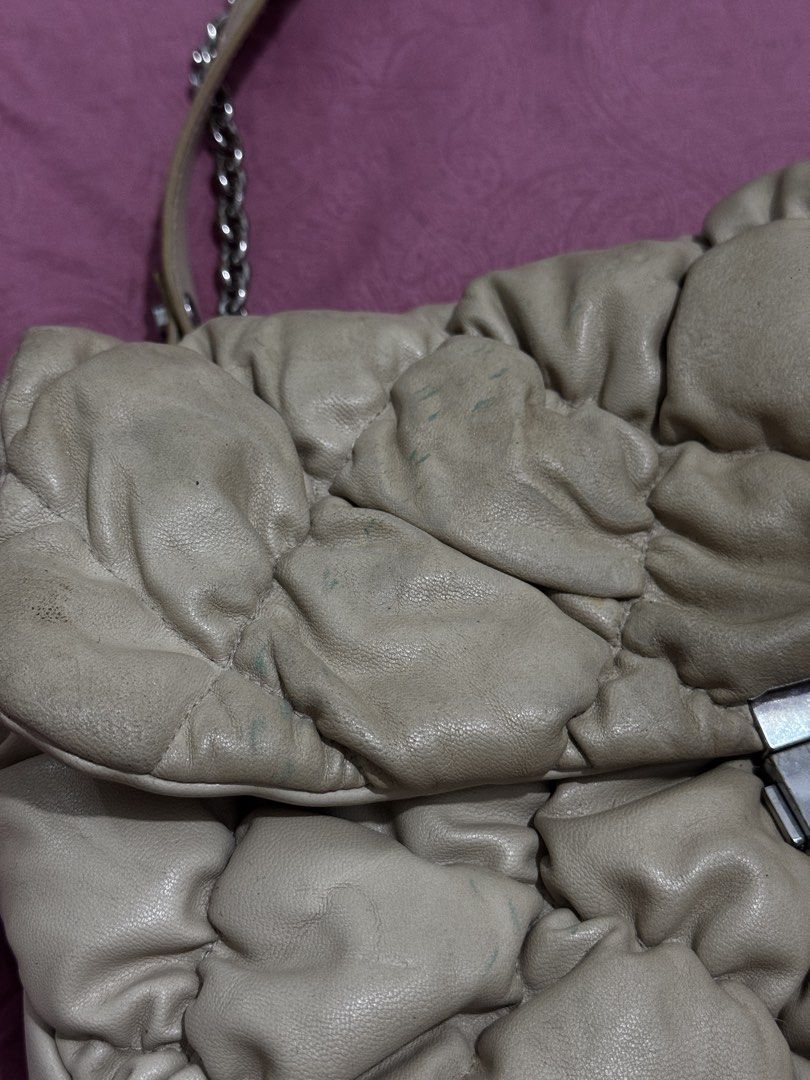 Quilted Leather Chain Shoulder Bag (Category: Shoulder Bags) located in Bauang. Submitted by jeneefromtheblock (Listing ID 1461774703, Image 3). Description: - Cream-colored quilted leather shoulder bag - Silver hardware with clasp closure - Chain strap with comfortable leather shoulder pad - Multiple interior compartments for organization - Marks on exterior leather - Clasp shows some signs of wear.