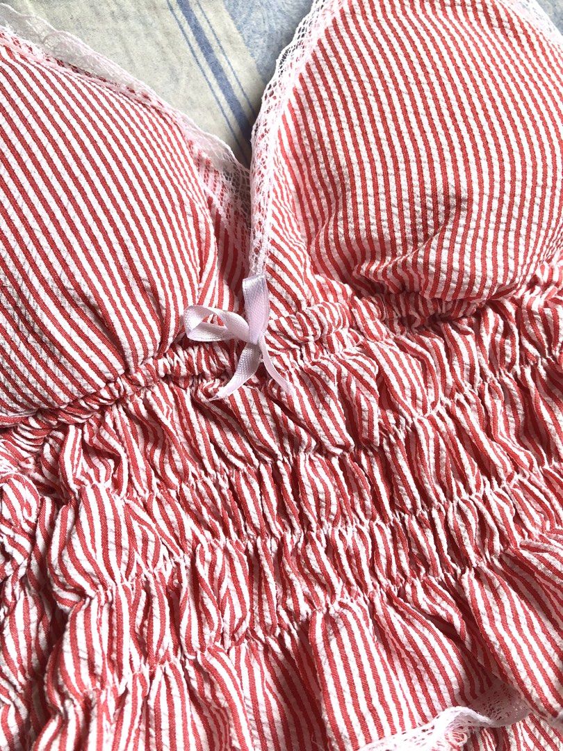 Red & White Striped Cottagecore Cami Top (Category: Others Tops) located in Manila. Submitted by franinvenus (Listing ID 1461618544, Image 2). Description: Ideal for B cup bust Vintage-inspired red and white pinstripes. Delicate white lace trimming along the neckline and hem. Cute satin bow accent at the center bust. Adjustable tie shoulder straps for a customizable fit. Fully smocked elastic bodice for a snug, flattering silhouette. Perfect for 