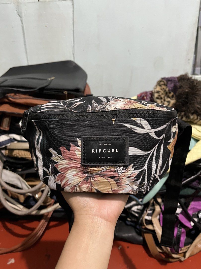 Ripcurl Floral Fanny Pack (Category: Belt bags, Clutches and Pouches) located in Manila. Submitted by bags_2.riches (Listing ID 1461617218, Image 1). Description: - Stylish black fanny pack with a vibrant floral print. - Features the iconic Ripcurl logo on the front. - Adjustable strap for a comfortable, customized fit. - Perfect for keeping your essentials secure and accessible hands-free. - Great for music festivals, travel, or everyday errands