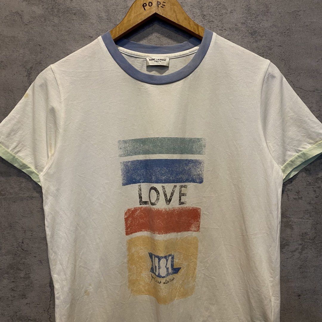 Saint Laurent Paris "1984" Tee (Category: Luxury Apparel) located in Quezon City. Submitted by rebirthalley (Listing ID 1461636124, Image 3). Description: Width-18 Length-25 Sleeve-7 Shoulder-15 Hem-18 Very Good Condition Need Wash Yellow Stains.