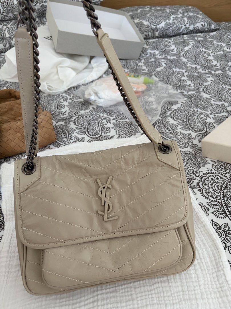Saint Laurent YSL Monogram Chain Bag Beige Leather (Category: Luxury Bags & Wallets) located in Taguig. Submitted by katdcp (Listing ID 1461579627, Image 2). Description: - Elegant beige YSL chain bag - Features classic chevron quilting on the front flap - Prominent YSL logo in the center - Includes a practical front pocket and a back pocket - Stylish dark grey metal chain strap - Versatile for everyday use or nights out.
