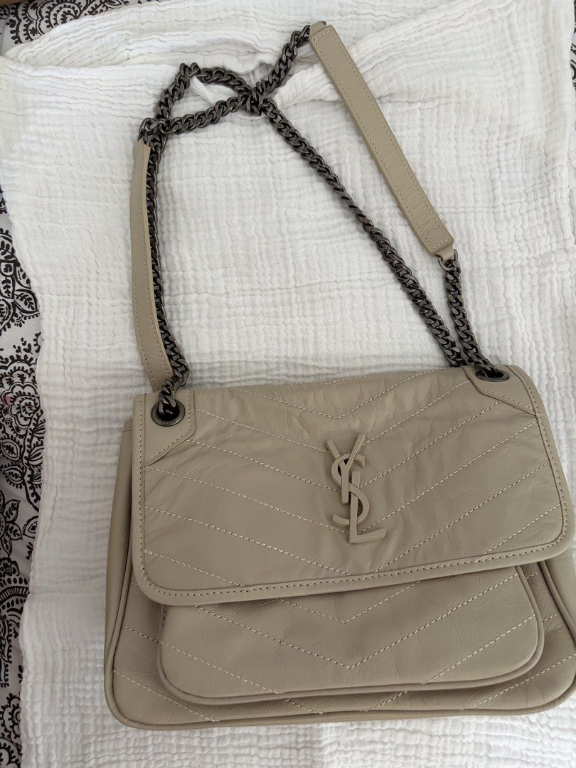 Saint Laurent YSL Monogram Chain Bag Beige Leather (Category: Luxury Bags & Wallets) located in Taguig. Submitted by katdcp (Listing ID 1461579627, Image 1). Description: - Elegant beige YSL chain bag - Features classic chevron quilting on the front flap - Prominent YSL logo in the center - Includes a practical front pocket and a back pocket - Stylish dark grey metal chain strap - Versatile for everyday use or nights out.