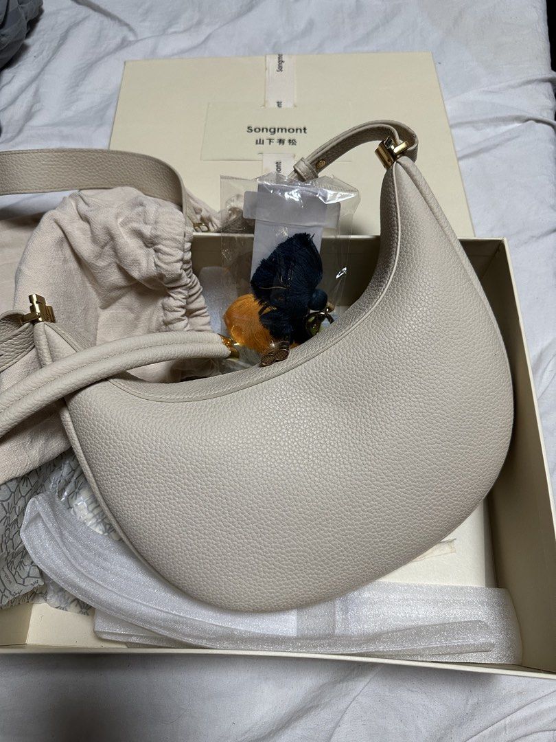 Songmont Luna Bag (Category: Cross-body Bags) located in Manila. Submitted by karlacotoc65578 (Listing ID 1461654275, Image 3). Description: Songmont Luna Bag Comes with the 2nd strap, 1 bag charm, dust bag and box Used once Size: Medium Color: Ivory RFS: Decluttering; not using it.
