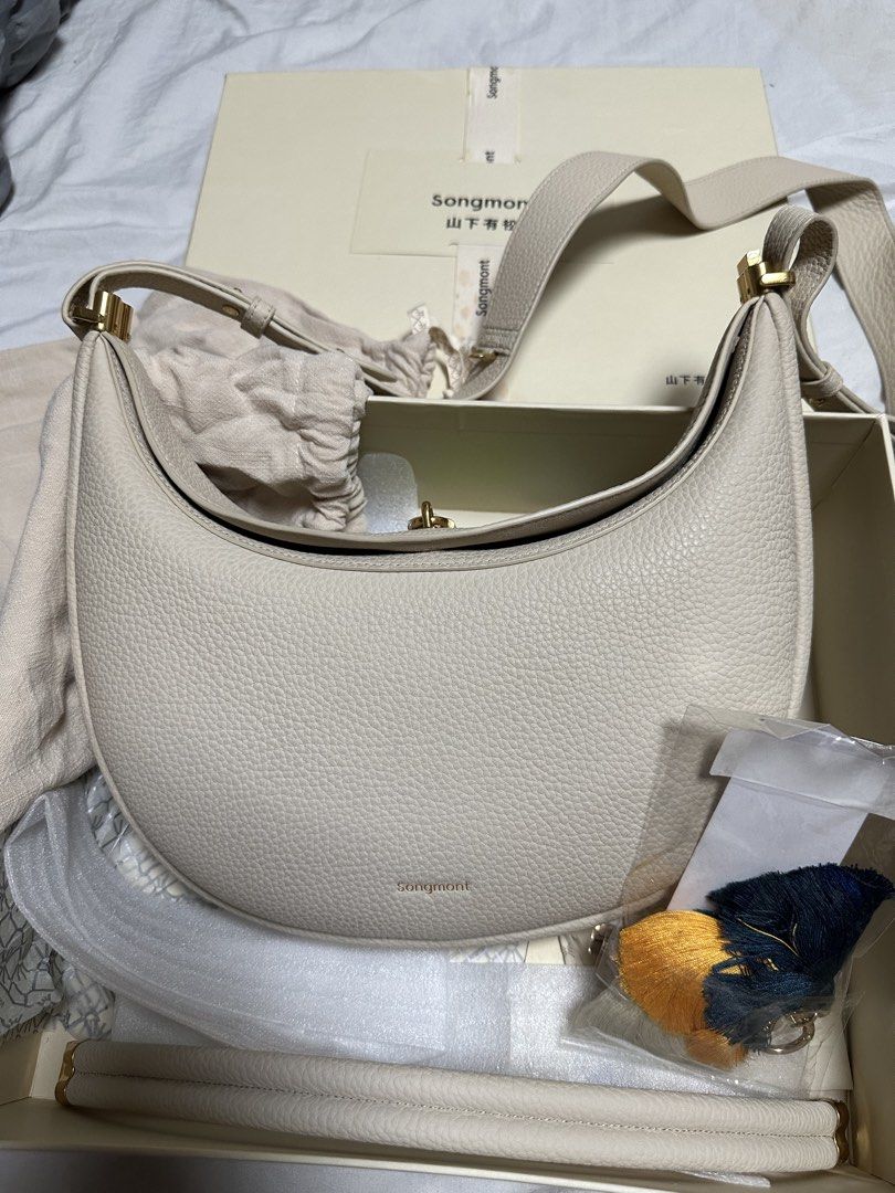 Songmont Luna Bag (Category: Cross-body Bags) located in Manila. Submitted by karlacotoc65578 (Listing ID 1461654275, Image 1). Description: Songmont Luna Bag Comes with the 2nd strap, 1 bag charm, dust bag and box Used once Size: Medium Color: Ivory RFS: Decluttering; not using it.
