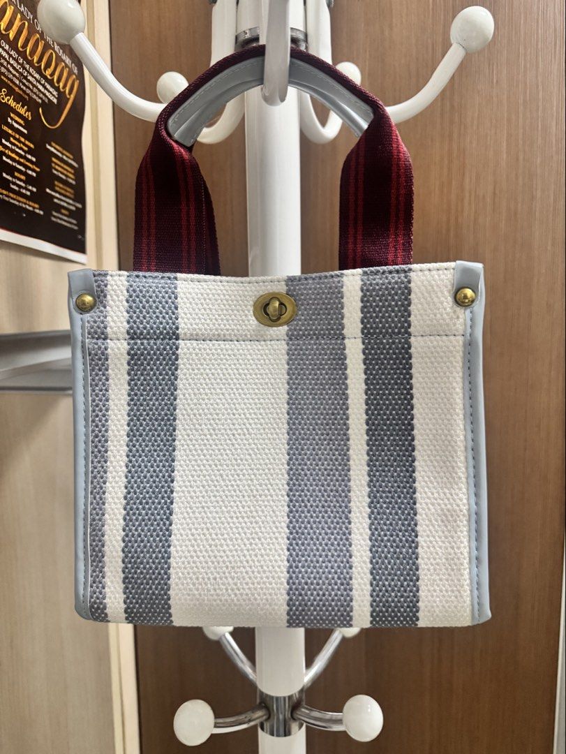 Striped Canvas Tote Bag with Red Straps (Category: Tote Bags) located in Bacoor. Submitted by _ibyangf (Listing ID 1461795565, Image 2). Description: - Cute striped tote bag - White and grey stripes on durable canvas material - Light blue trim for a stylish accent - Red fabric straps with comfortable grey handles - Secure twist lock closure at the top - Small and compact, ideal for everyday essentials and quick errands Once used only during our t