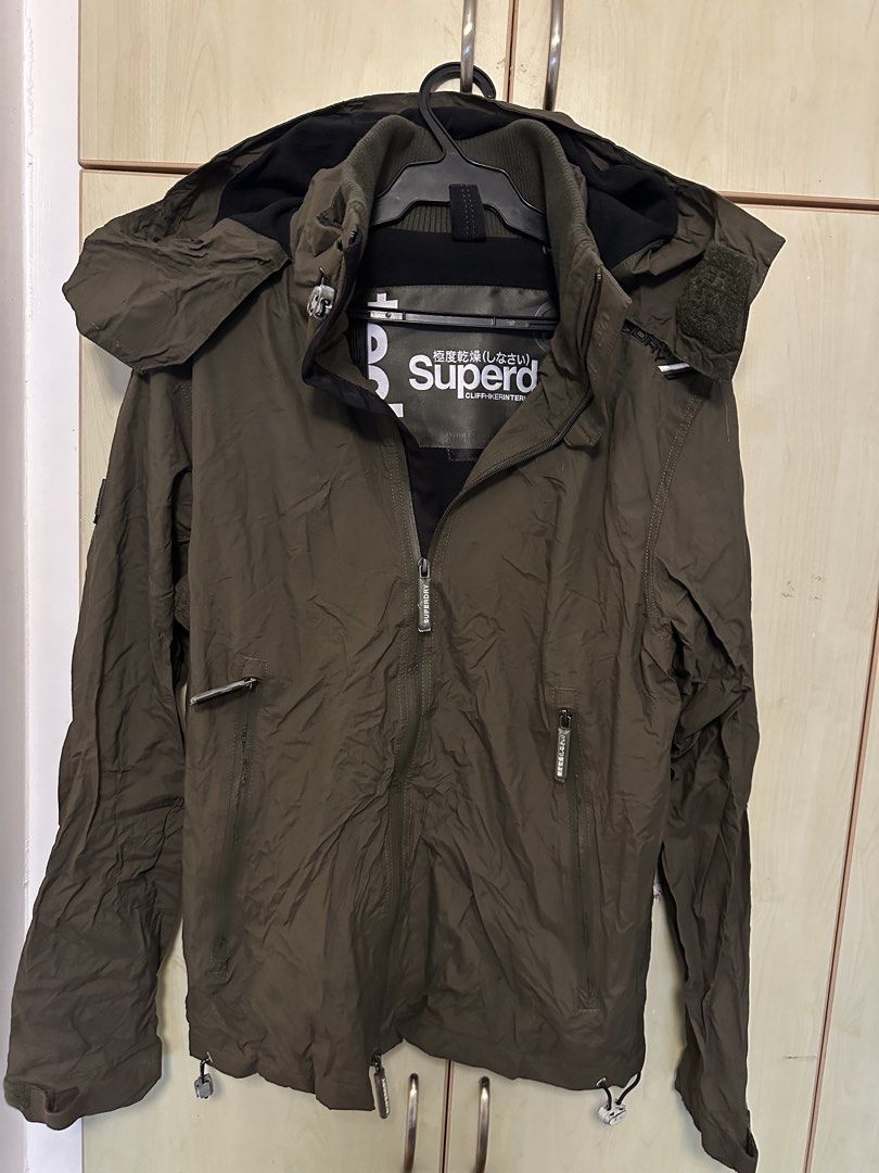 Superdry hooded windcheater Jacket (Category: Coats, Jackets and Outerwear) located in Quezon City. Submitted by mancave_stuff (Listing ID 1461647820, Image 2). Description: - Superdry Jacket - Color: Olive Green - Size: Large (W22” x L29”) - Features: Hood, multiple zip pockets - Adjustable hem with drawstrings - Ideal for outdoor activities and casual wear - Excellent condition. No issue.