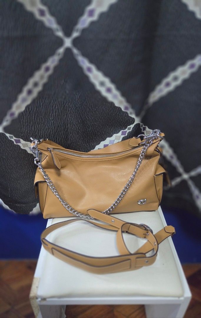 Tan Leather Shoulder Bag with Silver Chain (Category: Shoulder Bags) located in Quezon City. Submitted by affordabags_cd (Listing ID 1461682694, Image 1). Description: - Genuine tan leather shoulder bag - Elegant silver chain strap detail - Secure zipper closure - Light-colored fabric interior lining - Includes a detachable shoulder strap for versatile styling - Proudly made in Vietnam.
