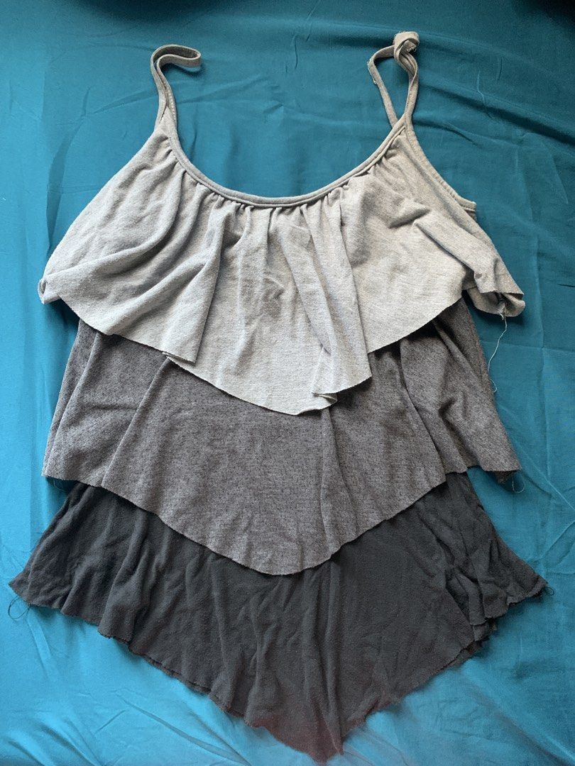 Tiered Ruffle Tank Top Grey (Category: Sleeveless) located in Paranaque City. Submitted by ashleyreads (Listing ID 1461567347, Image 1). Description: - Grey tiered tank top - Flowy look with ruffle layers - Spaghetti straps - Ideal for casual wear - Pairs well with shorts or jeans - Comfortable material.