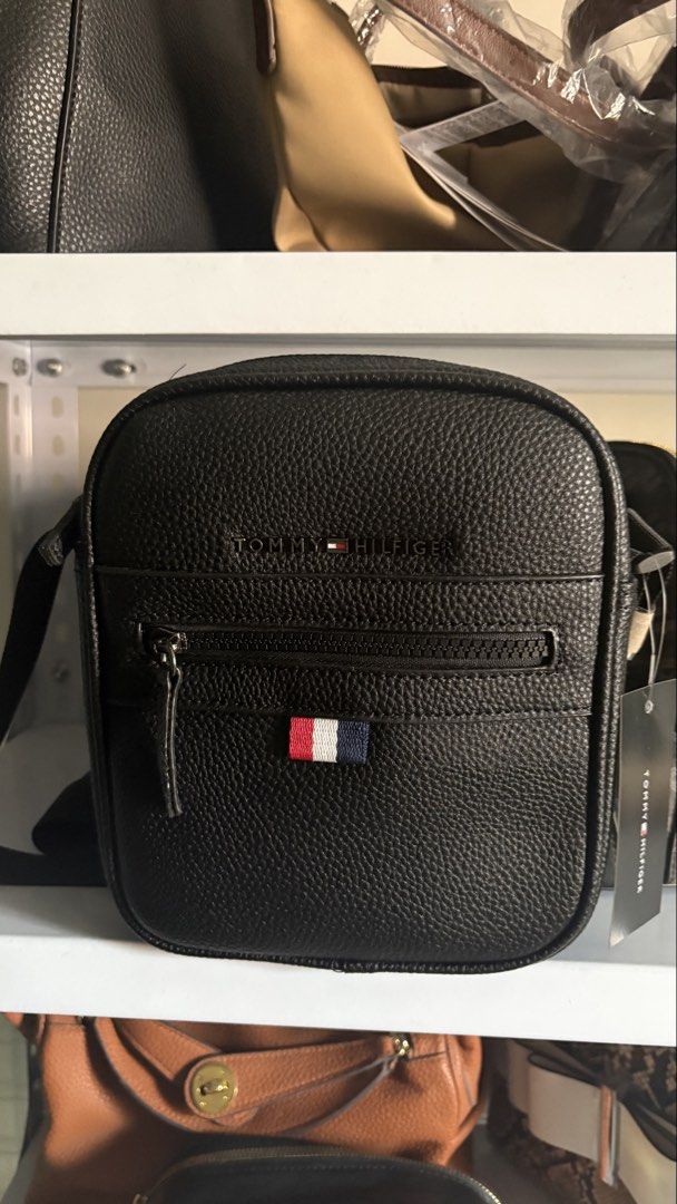 Tommy Hilfiger (tg) (Category: Cross-body Bags) located in Manila. Submitted by kathrinafu07589 (Listing ID 1461656590, Image 1). Description: - Authentic Tommy Hilfiger black leather crossbody bag - Embossed Tommy Hilfiger logo on the front - Small flag detail below the zipper - Adjustable strap for comfortable wear - Ideal for everyday use.