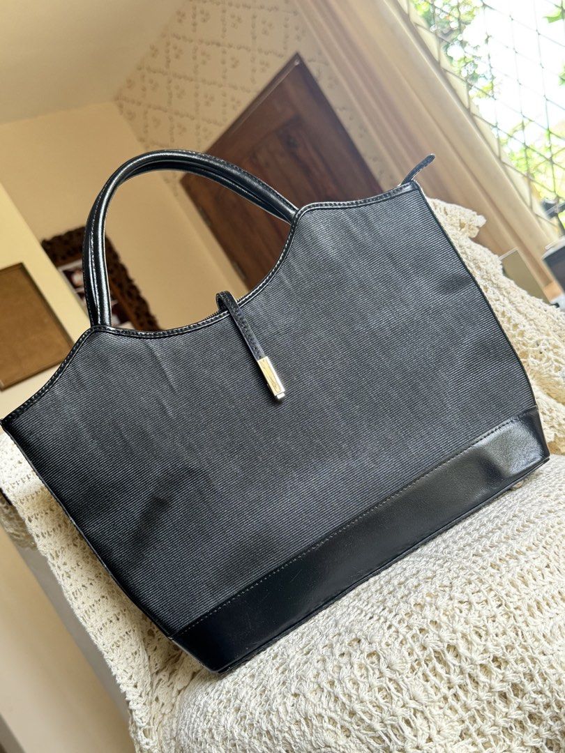 Tote Bag Black Canvas and Leather (Category: Tote Bags) located in Bacolod City. Submitted by vintage_vogue6100 (Listing ID 1461670411, Image 1). Description: - Color: Black - Material: Canvas body with leather trim and handles - Exterior Features: Zippered pocket on the back - Interior Features: Lined with a zippered compartment - Style: Classic, great for everyday use - Capacity: Plenty of space inside.