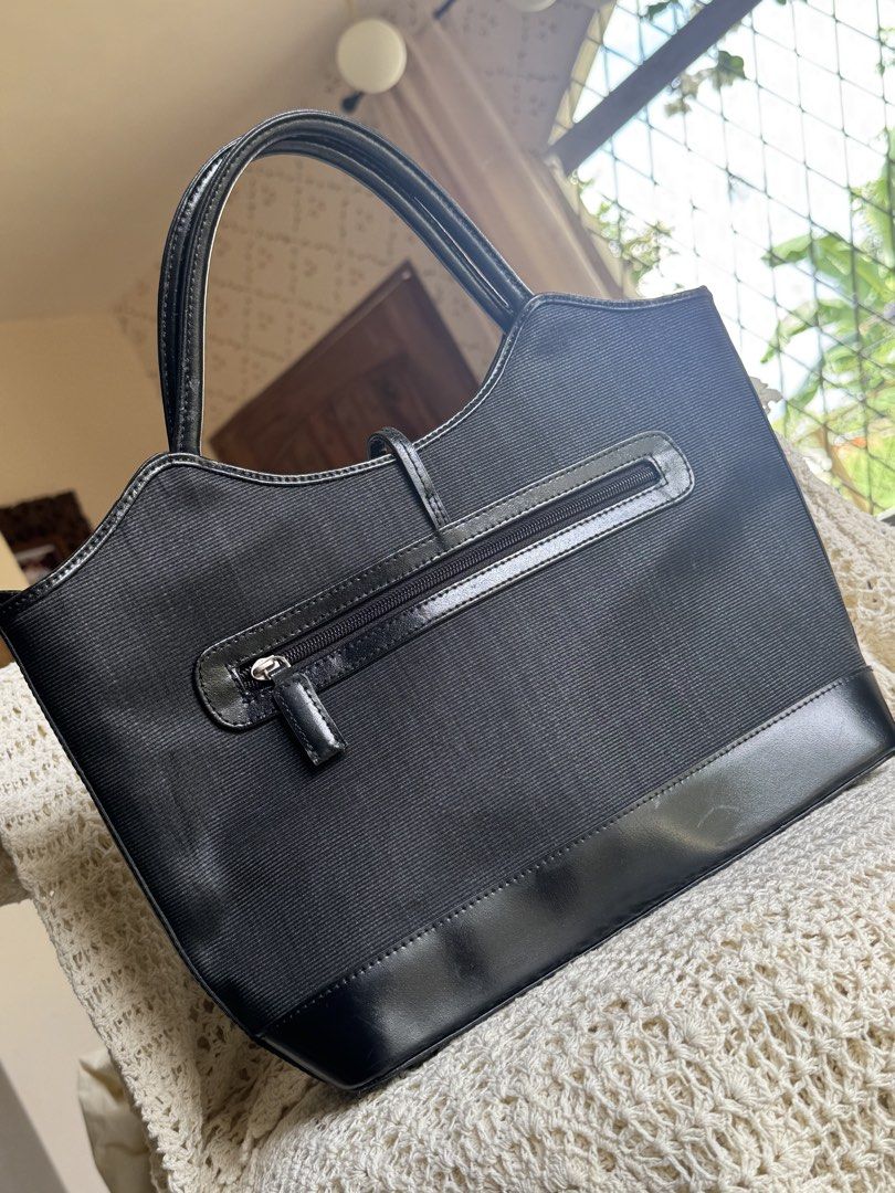 Tote Bag Black Canvas and Leather (Category: Tote Bags) located in Bacolod City. Submitted by vintage_vogue6100 (Listing ID 1461670411, Image 2). Description: - Color: Black - Material: Canvas body with leather trim and handles - Exterior Features: Zippered pocket on the back - Interior Features: Lined with a zippered compartment - Style: Classic, great for everyday use - Capacity: Plenty of space inside.