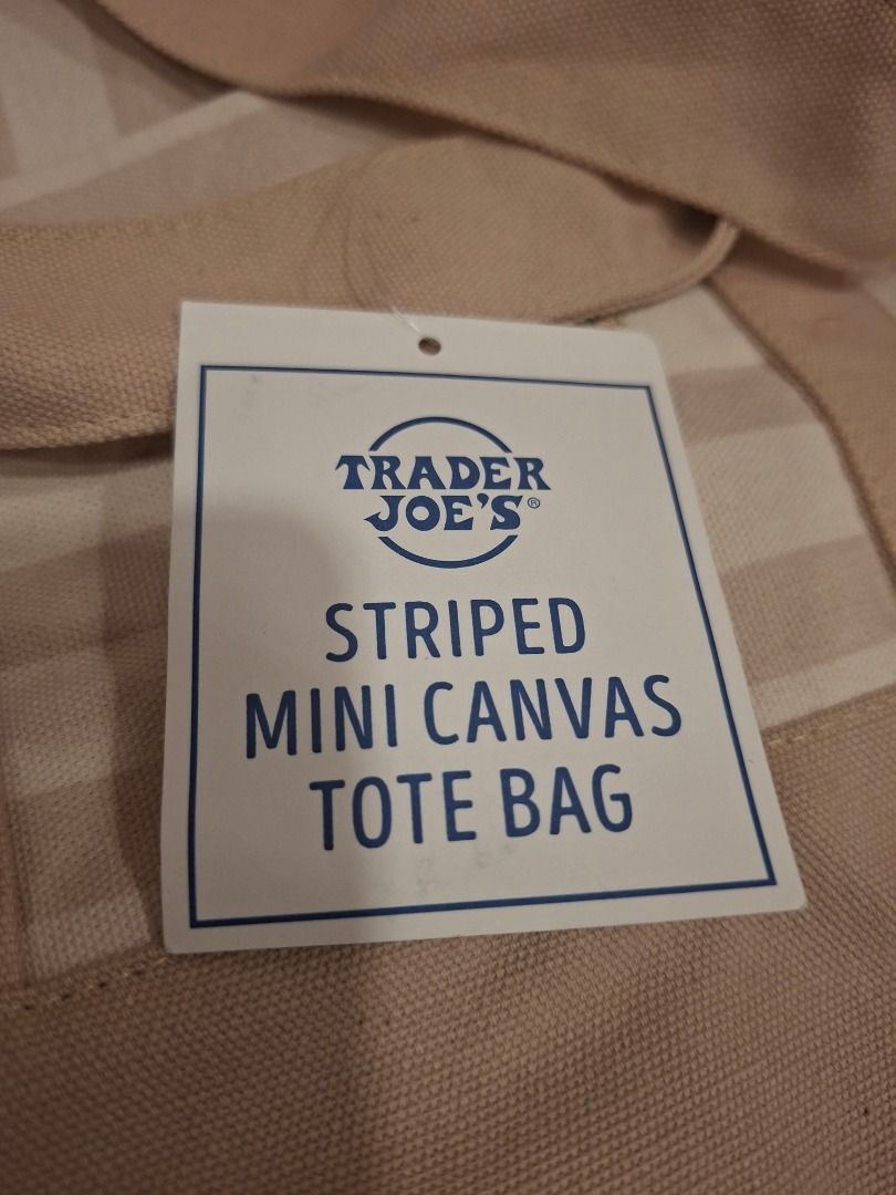 Trader Joe's Striped Mini Canvas Tote Bag (Category: Tote Bags) located in Makati City. Submitted by bocerelije18527 (Listing ID 1461757406, Image 3). Description: - Adorable mini canvas tote bag from Trader Joe's - Features a chic beige and white striped pattern - Convenient small front pocket for essentials - Embroidered Trader Joe's logo detail - Material: 65% Cotton, 35% Polyester - Origin: Product of Vietnam - Care Instructions: Machine wash
