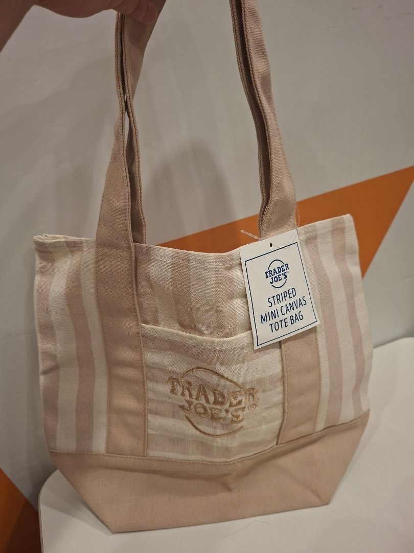 Trader Joe's Striped Mini Canvas Tote Bag (Category: Tote Bags) located in Makati City. Submitted by bocerelije18527 (Listing ID 1461757406, Image 2). Description: - Adorable mini canvas tote bag from Trader Joe's - Features a chic beige and white striped pattern - Convenient small front pocket for essentials - Embroidered Trader Joe's logo detail - Material: 65% Cotton, 35% Polyester - Origin: Product of Vietnam - Care Instructions: Machine wash