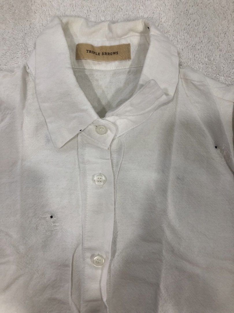 Triple Arrows White Embroidered Button-Up Shirt (Category: Longsleeves) located in Manila. Submitted by janmichael26601 (Listing ID 1461625425, Image 3). Description: - Brand: Triple Arrows - Style: White button-up shirt - Design: Adorable embroidered bunnies all over - Sleeves: Long sleeves with button cuffs - Flaw: Small stain on the front near the buttons - Measurements: Approx. 21" pit to pit, 27" length.