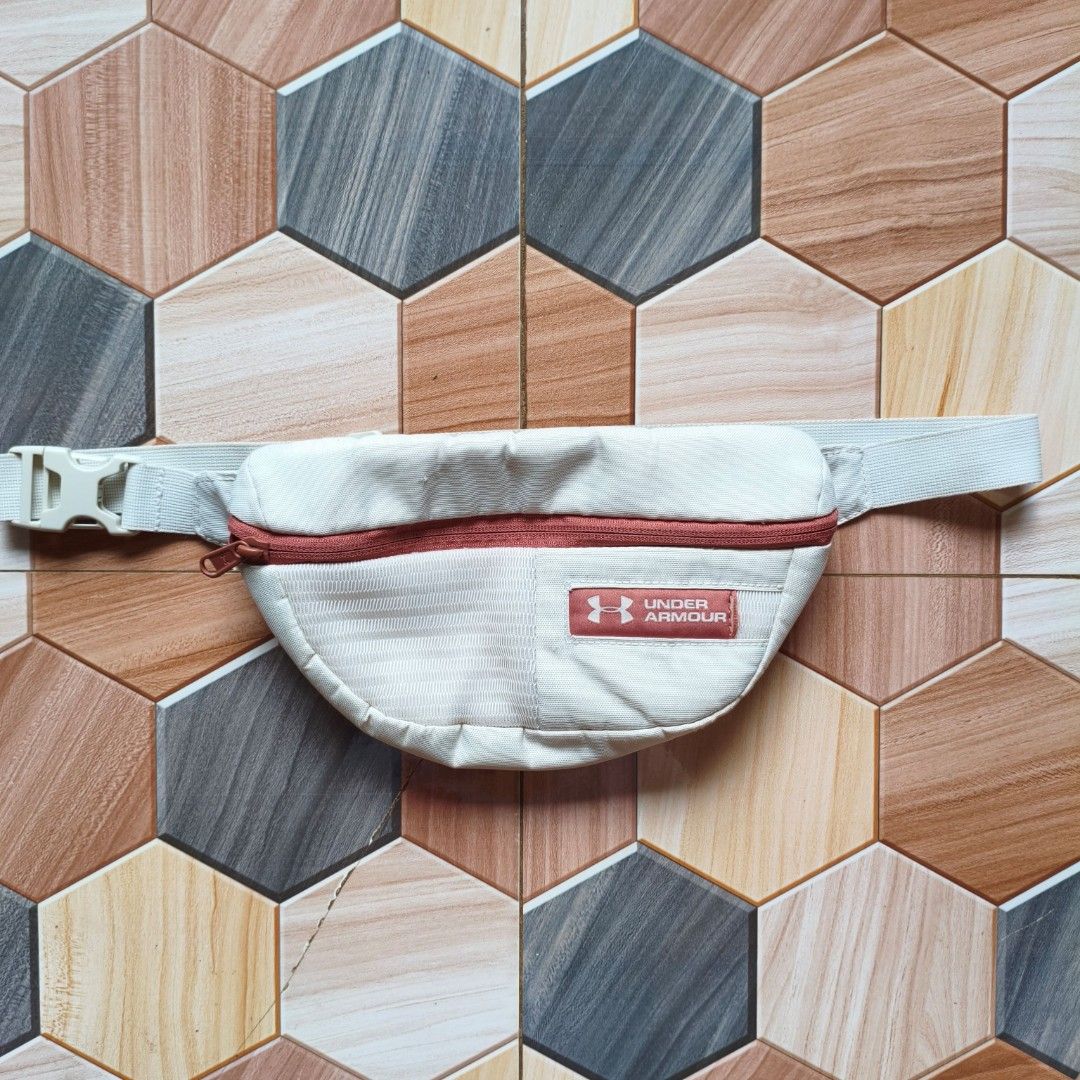 Under Armour White Fanny Pack Bum Bag (Category: Belt bags, Clutches and Pouches) located in Manila. Submitted by caps08 (Listing ID 1461594637, Image 1). Description: - White Under Armour fanny pack - Reddish-brown zipper and logo patch - Adjustable strap with buckle closure - Ideal for keeping essentials handy - Perfect for workouts or casual outings - Shows minimal signs of wear.