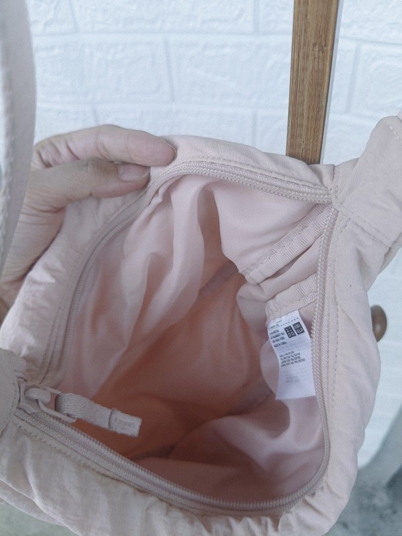 Uniqlo Dumpling Bag (Category: Shoulder Bags) located in Cavite. Submitted by j_creations18 (Listing ID 1461582278, Image 2). Description: - Uniqlo Dumpling Bag - Color: Light Pink - Adjustable strap - Main compartment with zipper closure - Water-repellent material - Ideal for everyday use - Fits essentials easily - with stains but not noticeable - Bought this for 799 .