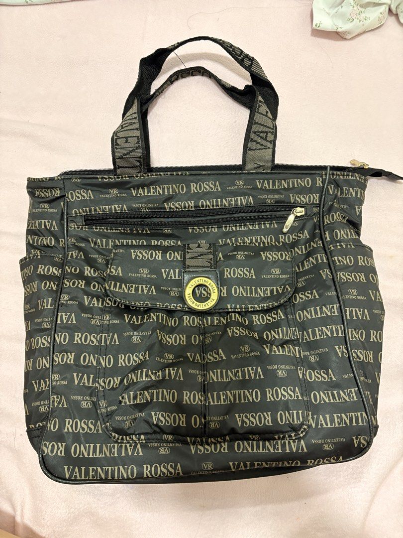 Valentino Rossa Monogram Tote Bag (Category: Luxury Bags & Wallets) located in Iligan City. Submitted by nebulanookph (Listing ID 1461600766, Image 2). Description: - Valentino Rossa tote bag - All-over logo print in gold lettering - Color: Dark brown - Zippered main compartment - Front pockets for easy access - Branded straps - Ideal size for everyday carry .