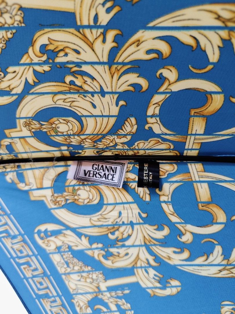 Versace (Category: Umbrellas) located in Davao. Submitted by dvo_jpnstuff (Listing ID 1461669931, Image 3). Description: G*a*ni V*rs*ce (Vintage long umbrella) Classic wooden crook handle and branded metal hardware w/ a blue and gold baroque-patterned featuring intricate, ornate scrollwork across the canopy Like new condition "NO visible or hidden issue" For additional details check each picture and vid or dm me. 📍Dvo (We ship nationwide via any