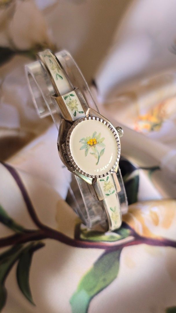 Vintage Andre Mouche Peekaboo Bangle Watch (Category: Women's Watches) located in Silang. Submitted by thewornhour (Listing ID 1461793811, Image 2). Description: Vintage André Mouche Swiss Enamel Bangle Watch – Hand-Painted Edelweiss Flower Locket ✔ All original watch ✔ Case: 16.8mm including crown ✔ Up to 16cm ✔ Movement: Precision Swiss Quartz ✔ Design: Unique piece features a rigid gold-tone bangle decorated with exquisite, hand-painted floral