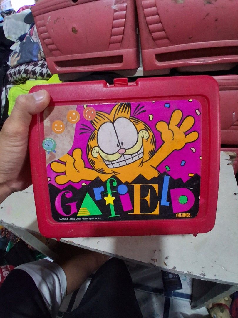 Vintage Garfield Thermos Lunch Box Red (Category: Food Organization & Storage) located in Manila. Submitted by marcas022798212 (Listing ID 1461576702, Image 1). Description: - Retro Thermos Garfield Lunchbox - Bright red plastic with classic Garfield graphic - Shows some signs of wear, consistent with age - Clasp works well - Interior is clean - Perfect for collectors or a fun retro vibe - Great for display or light use.