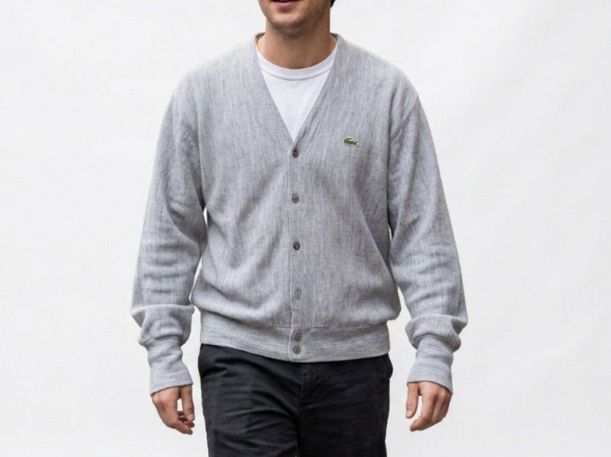 VINTAGE IZOD LACOSTE WOOL CARDIGAN (Category: Coats, Jackets and Outerwear) located in Davao. Submitted by thrift_cuttiiee1000 (Listing ID 1461714992, Image 1). Description: Vintage Izod Lacoste acrylic V-neck cardigan in heather grey. Brand: Izod Lacoste — specifically from the era (spanning roughly the 1970s through early 1990s) when American manufacturer Izod held the US licensing rights for France's Lacoste. Tag Era: The white tag with the gr